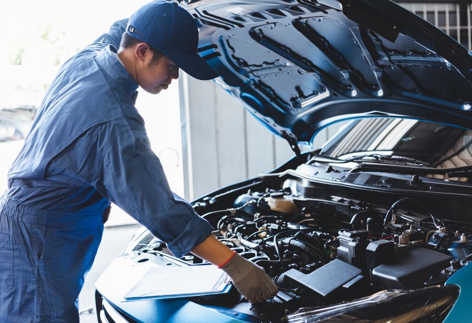 man inspecting under the hood of a car